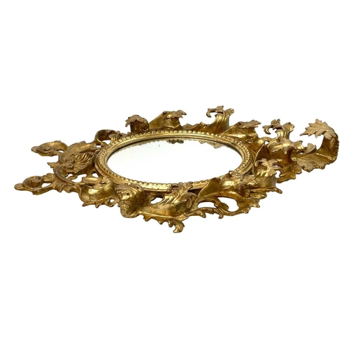 322 - An ornate Florentine oval giltwood rococo style wall mirror. Circa 1900, with typical shell and scro... 