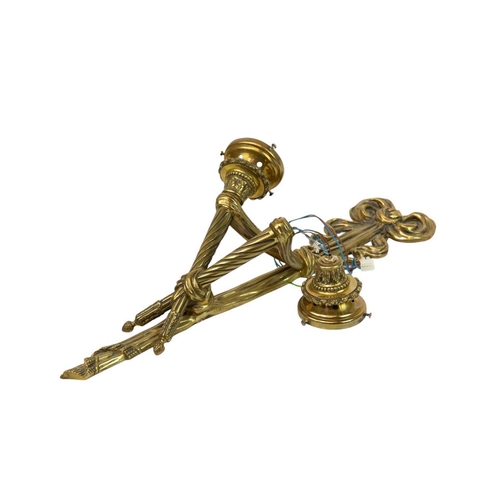 323 - A large late 19th/20th century French brass wall applique. With twin scones issuing from a ribbon an... 