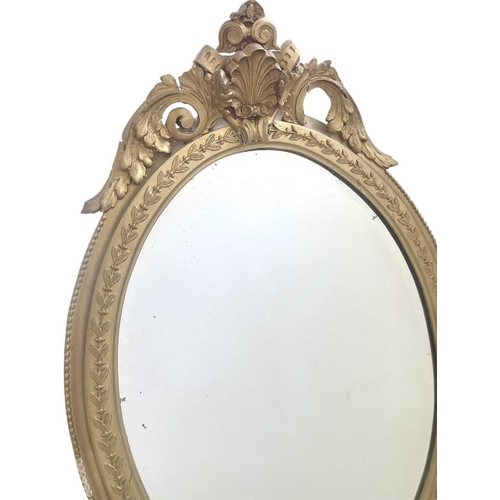 336 - A 19th century gilt gesso oval wall mirror. With shell and scroll cresting, height 96cm, width 57cm.