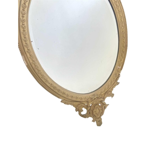 336 - A 19th century gilt gesso oval wall mirror. With shell and scroll cresting, height 96cm, width 57cm.