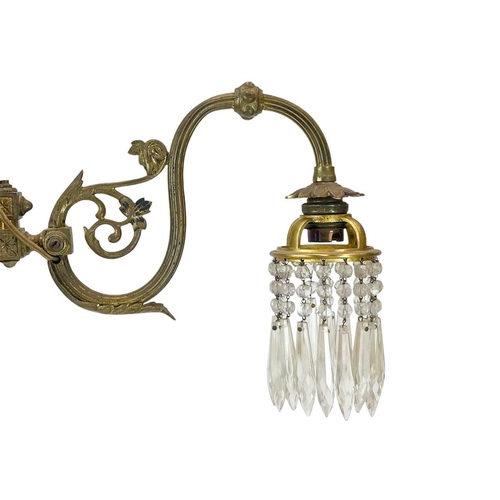 338 - A pair of cast brass wall lights. With crystal drops, height 21cm, depth 30cm (2).