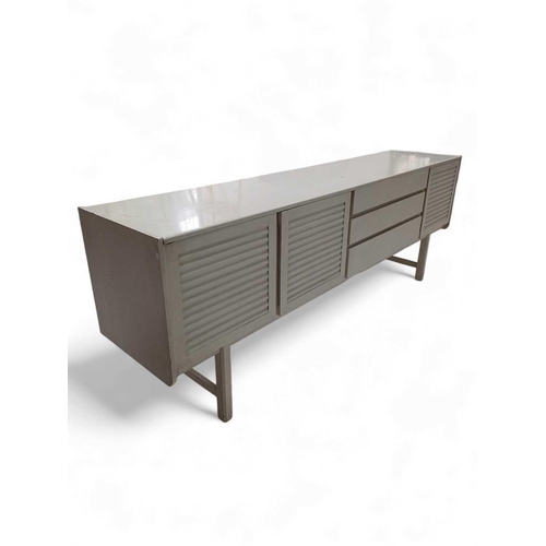 416 - An A H Mcintosh mid-century white finish sideboard. With three louvre effect doors, and three drawer... 