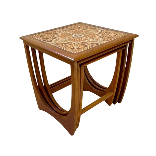 417 - A nest of three G Plan teak occasional tables. The larger table with a tiled top, height 51cm, width... 