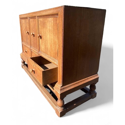 418 - A Heals light oak sideboard. Fitted two doors flanking a deep cellarette drawer, with three further ... 