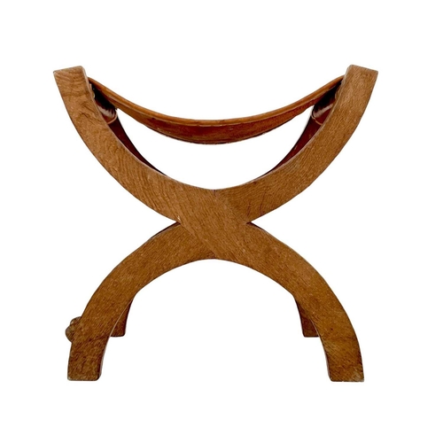 420 - A Robert Thompson 'Mouseman' oak X-frame stool. With a slung leather seat and curved supports, carve... 