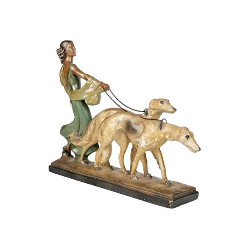 438 - An Art Deco spelter figure of a kneeling lady and greyhound. On a marble base, with an attahed plaqu... 