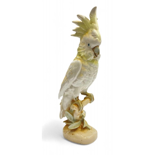 572 - A Royal Dux porcelain figure of a cockatoo perched on a branch. Decorated in yellow, height 41cm.