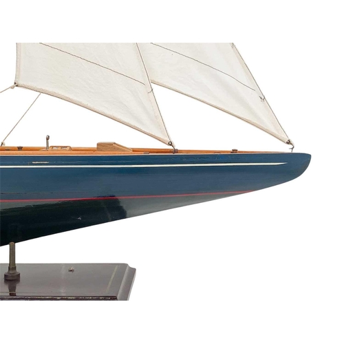 61 - A model of a yacht. Modern, with a blue painted hull, on a painted base, height 110cm.