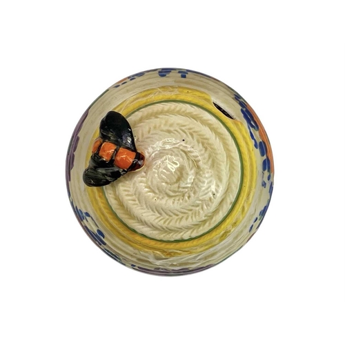 667 - A Clarice Cliff Gay Day beehive honey and cover. Bizarre Wilkinson marks, height 9cm.