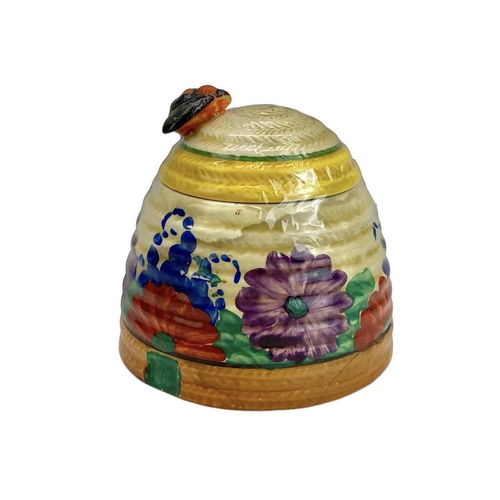 667 - A Clarice Cliff Gay Day beehive honey and cover. Bizarre Wilkinson marks, height 9cm.