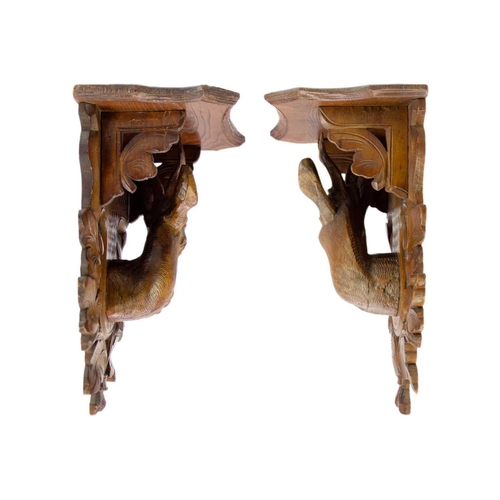 75 - A pair of Black Forest linden wood wall brackets. Late 19th century, each carved with a stag head an... 