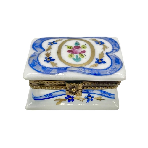 772 - Three Limoges porcelain trinket boxes. Each with painted floral decoration, largest height 6.5cm. (3... 