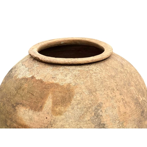 815 - A terracotta storage jar. On wire stand, height 83cm.