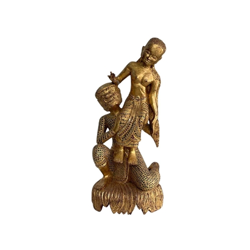 83 - A Burmese lacquered gilt figure group. Height 60cm.