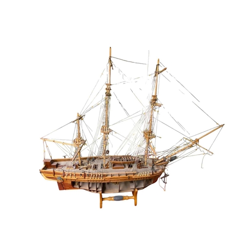 229 - A wooden model of HMS Bounty With detailed rigging, small cannon and upon a stand, open hull to one ... 