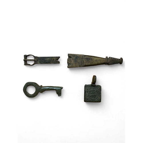 283 - Medieval Bronze A horse harness pendant 15mm wide, a bronze thimble, a key 3.5cm and a strap end and... 