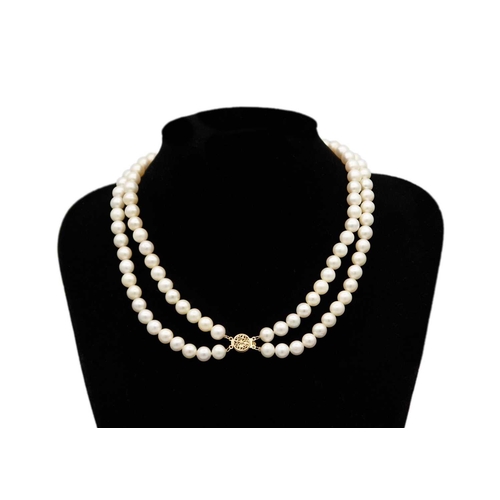 102 - A cultured white pearl double strand necklace with 14ct clasp. The uniform pearls of 7.5-8mm, the pi... 