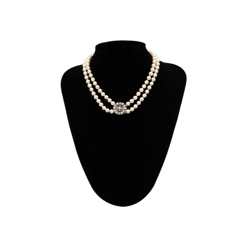 106 - An early 20th century double-strand white pearl necklace with 18ct white gold diamond set clasp. The... 