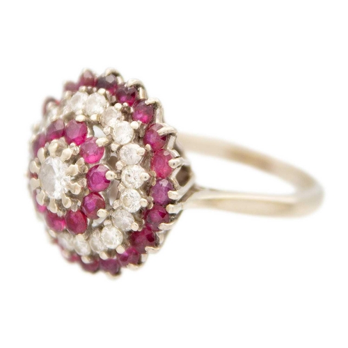 120 - An 18ct white gold ruby and diamond set cluster target ring. The central principle diamond of 0.15ct... 