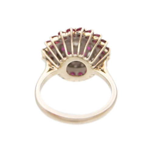 120 - An 18ct white gold ruby and diamond set cluster target ring. The central principle diamond of 0.15ct... 