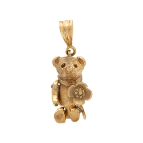 124 - A 9ct gold articulated bear charm/pendant The bear has a flower in it's paw, a bow on the back, stam... 