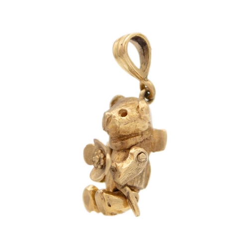 124 - A 9ct gold articulated bear charm/pendant The bear has a flower in it's paw, a bow on the back, stam... 