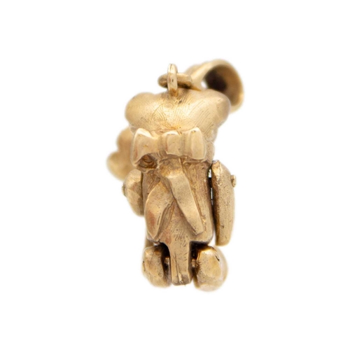 124 - A 9ct gold articulated bear charm/pendant The bear has a flower in it's paw, a bow on the back, stam... 