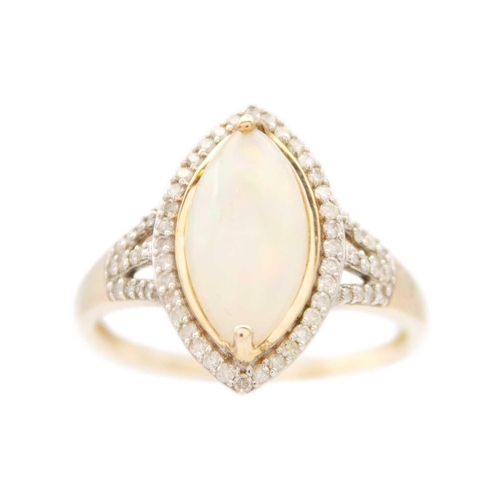 130 - A 9ct white opal and diamond set dress ring. The marquise shaped cabochon opal displaying multiple c... 