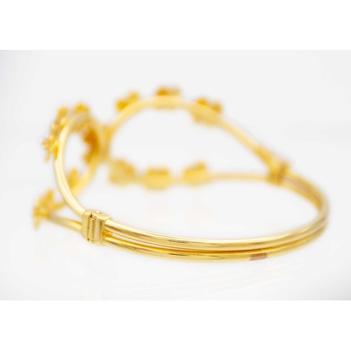 133 - High purity gold bangle applied with flower heads Stamped 916, 26.88g weight. Comes in original Aluk... 