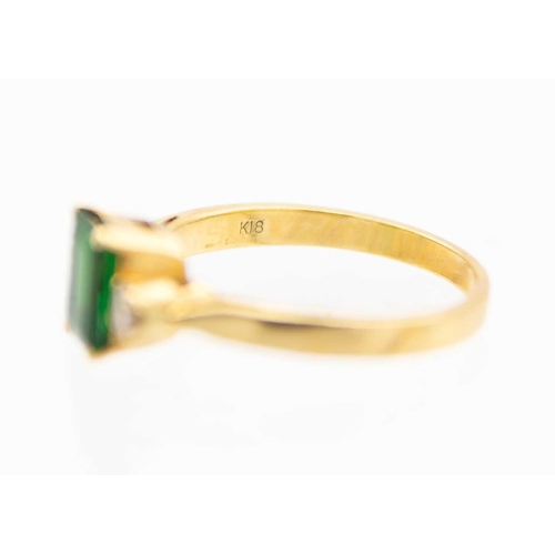 148 - An 18ct synthetic emerald and diamond set three-stone ring. The emerald of 1.30ct estimated weight, ... 