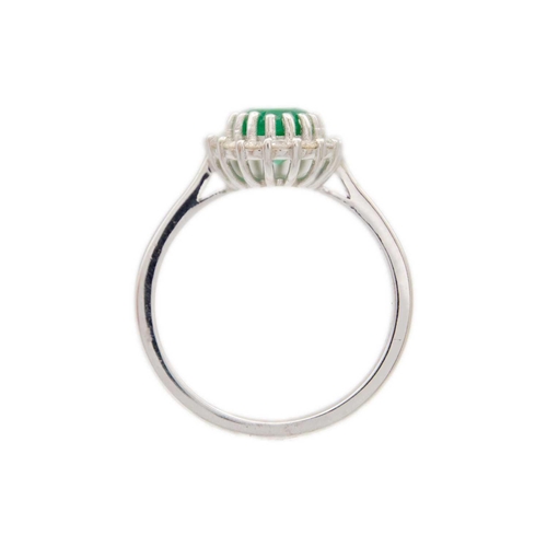 149 - An 18ct white gold oval emerald and diamond set cluster ring. The emerald of 1.30ct estimated weight... 