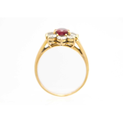 180 - A modern Chinese 18ct ruby and diamond cluster ring. The oval cut ruby of 0.85ct estimated weight, s... 