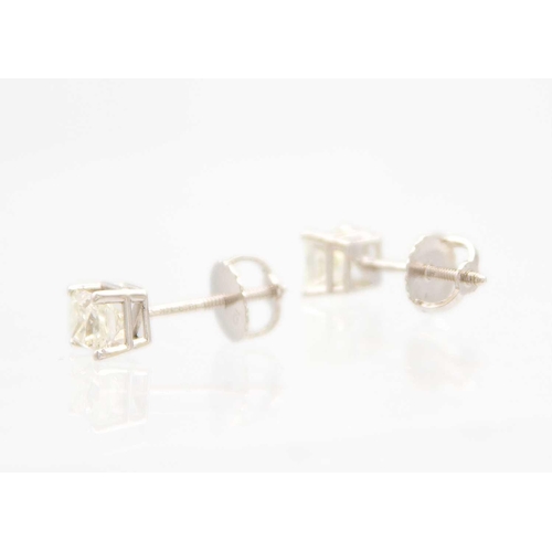 211 - A pair of 14ct white gold princess cut diamond solitaire stud earrings. The diamonds of 0.90ct total... 