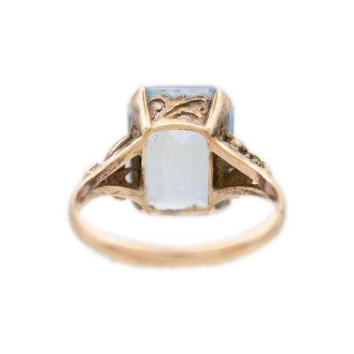 214 - A 14ct yellow gold blue synthetic spinel cocktail ring. With foldover motive on the shoulders of the... 