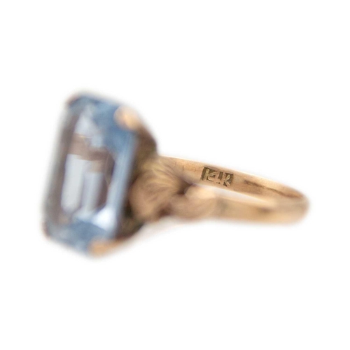 214 - A 14ct yellow gold blue synthetic spinel cocktail ring. With foldover motive on the shoulders of the... 