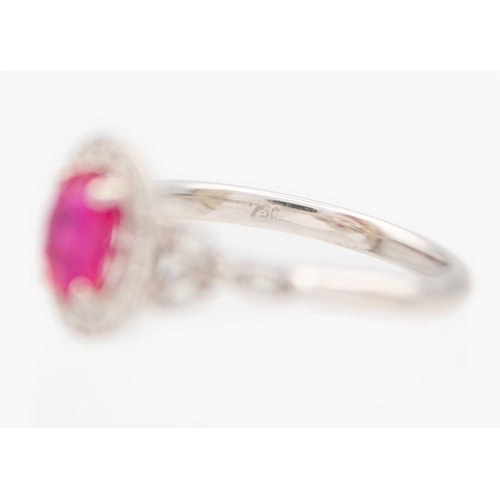 230 - A 1.03ct ruby and diamond set halo ring, set in 18ct white gold. By River Mounts. The oval cut ruby ... 