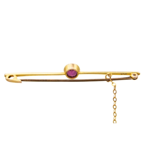 239 - A 9ct bar brooch set with a solitaire garnet. .A beautiful purpulish pink round cut rhodolite garnet... 