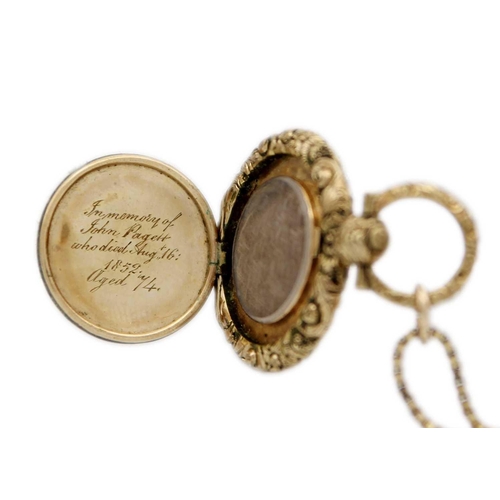 249 - A 19th century gold mourning locket pendant. With foliate embossed and chased edge, with memorial en... 