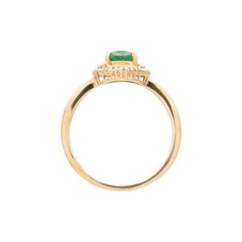 256 - A 9ct emerald and diamond set dress ring. The oval cut emerald of 1.02ct estimated weight, surrounde... 