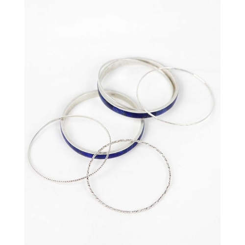 259 - A selection of silver bangle bracelets Two bangles are inlayed with lapis lazuli .