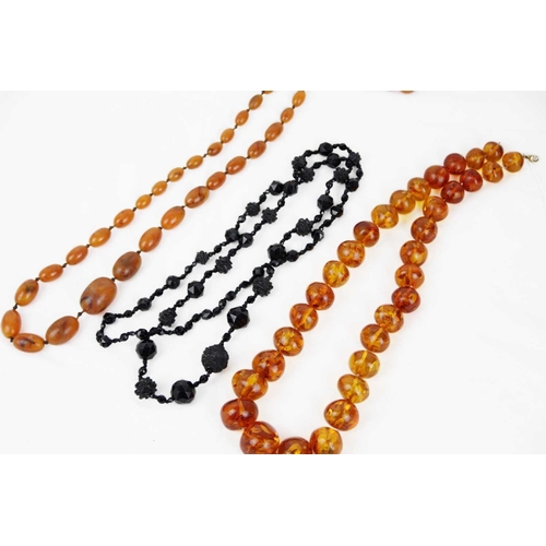 298 - A bakelite 'amber' graduated bead necklace and a jet bead necklace with matching earrings. The 'ambe... 