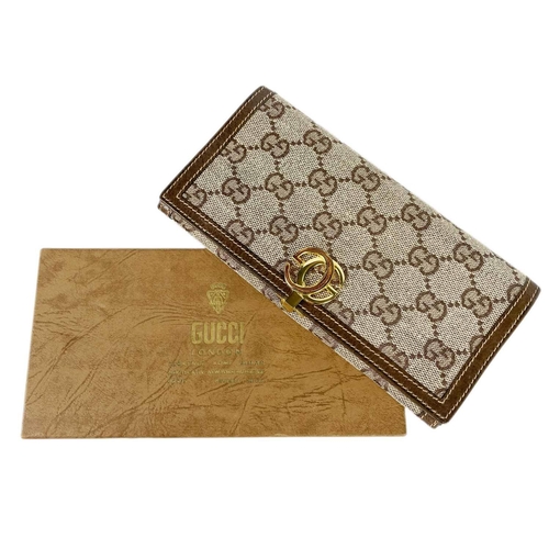 322 - GUCCI - A wallet in embroidered GG fabric and brown leather trim. In original cardboard box; width 1... 