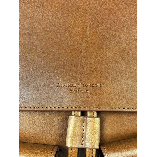 326 - ASPINAL OF LONDON - A heritage style tan leather drawstring backpack. The front with a pair of envel... 