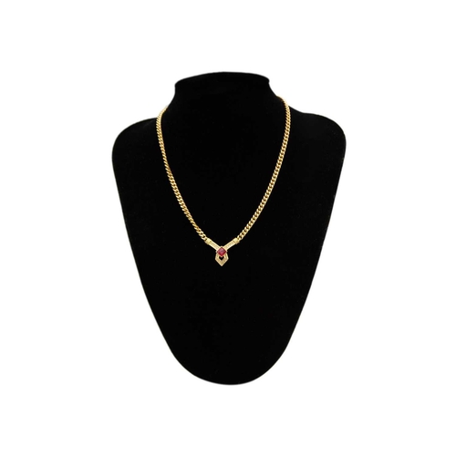 357 - CHRISTIAN DIOR - A gold-tone paste set pendant necklace. The V shaped pendant on a curb link chain, ... 