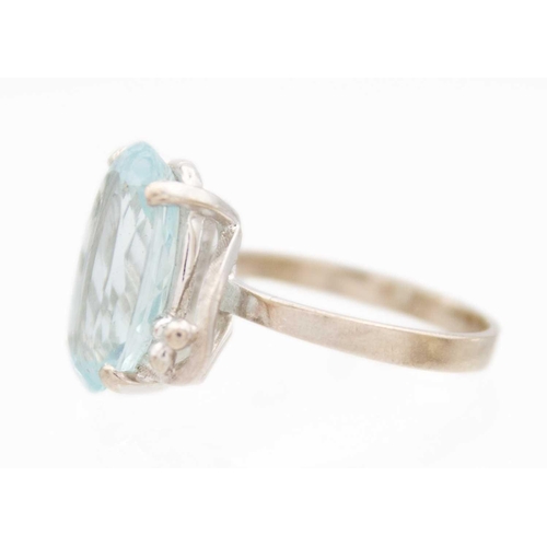 41 - A platinum aquamarine set dress ring. The oval cut aquamarine of 4.15ct estimated weight, in a four ... 