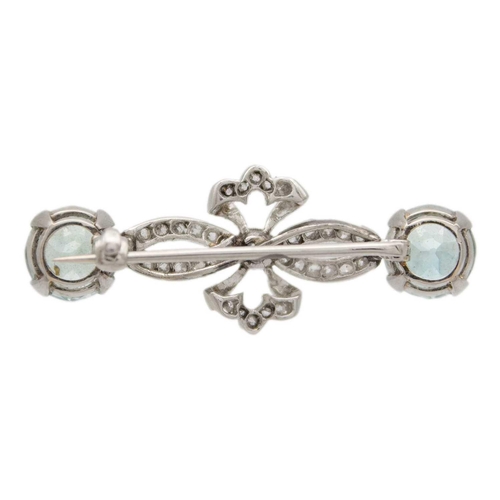 42 - An attractive early 20th-century diamond and blue zircon, white gold set brooch. Of bow design set w... 