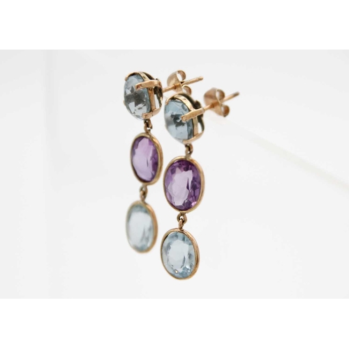 73 - A pair of amethyst and blue topaz set gold mounted (tests 14ct) pendant earrings. The stones of oval... 