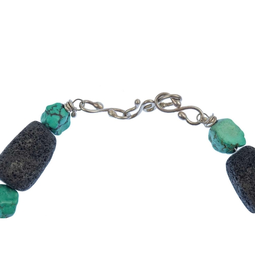 77 - HELEN FEILER - A volcanic stone and turquoise bead silver necklace. With silver wire spacers, length... 