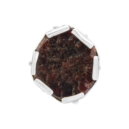 87 - HELEN FEILER - A silver garnet specimen set ring. The panel head measuring 25 x 24mm, size M, 22.5g.