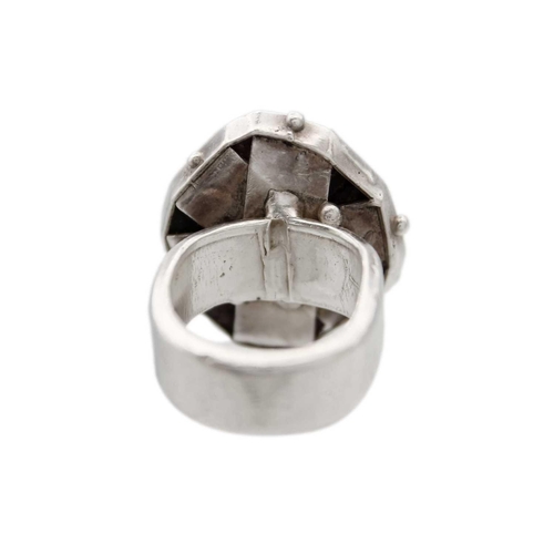 87 - HELEN FEILER - A silver garnet specimen set ring. The panel head measuring 25 x 24mm, size M, 22.5g.